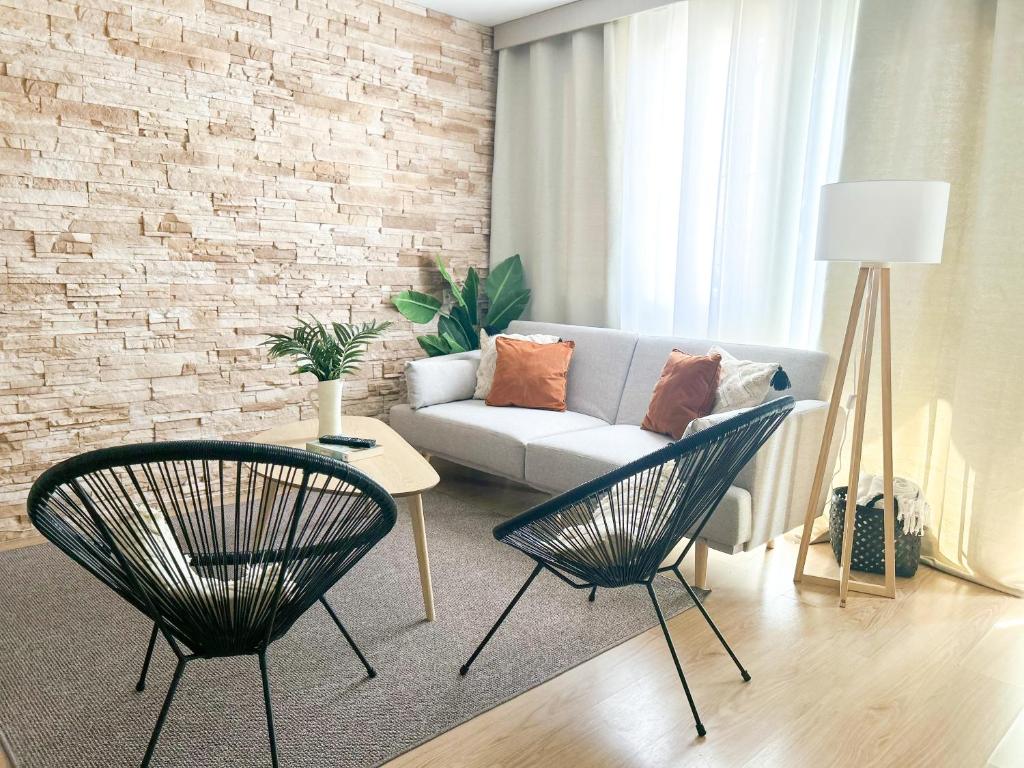 uma sala de estar com um sofá e duas cadeiras em Apartamento Brisas em Sevilha