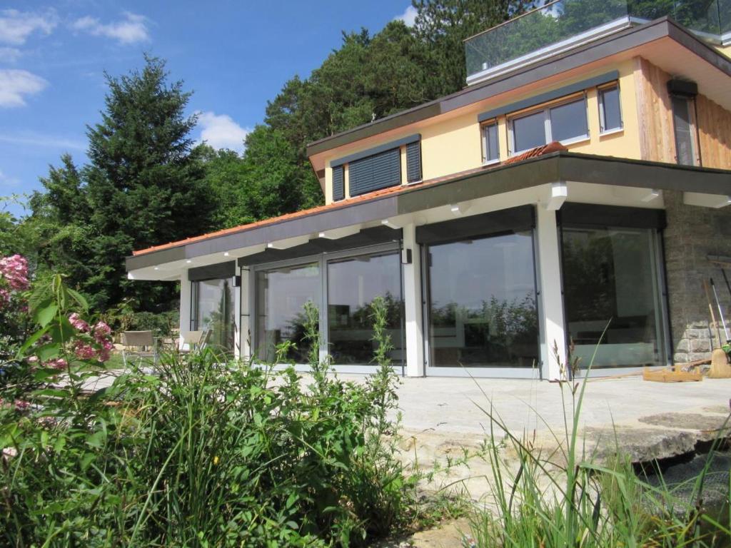 a house with large sliding glass doors at Ferienhaus hoch über dem Taubertal mit fantastischem Weitblick, Dachterrasse, 2000m2 großem Grundstück und Kamin in Lauda-Königshofen