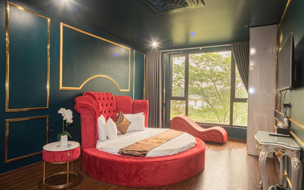Schlafzimmer mit einem roten Bett und einem roten Stuhl in der Unterkunft Royal Hotel & Apartment in Hanoi