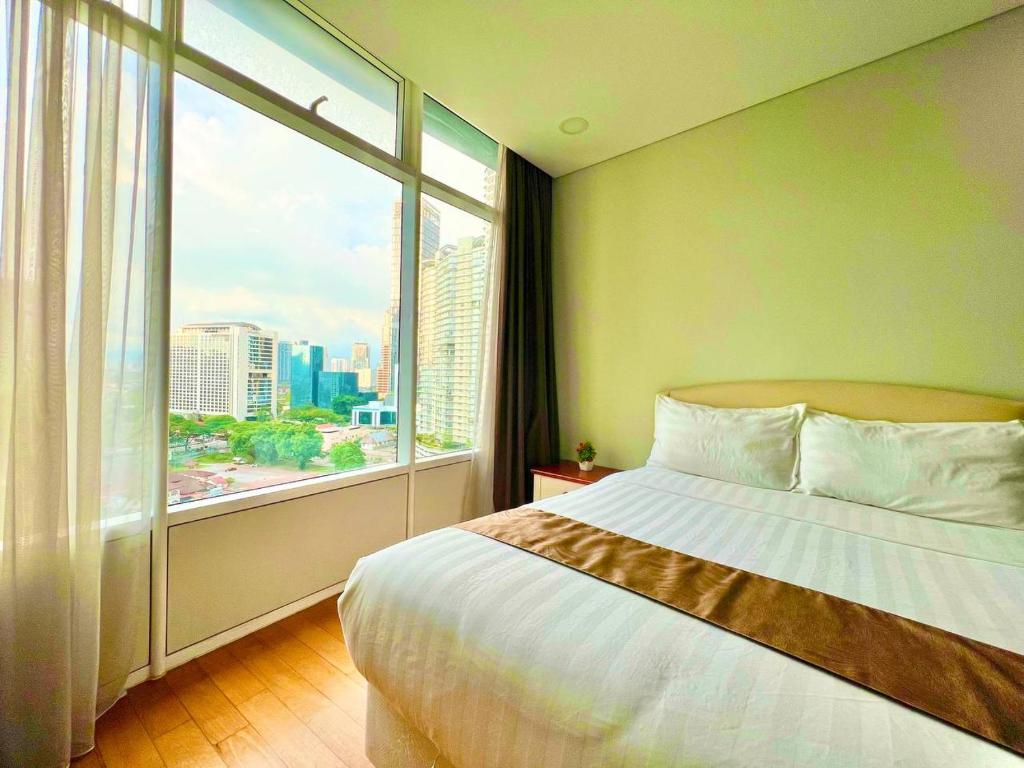 a bedroom with a bed and a large window at Vortex suites near by KLCC in Kuala Lumpur