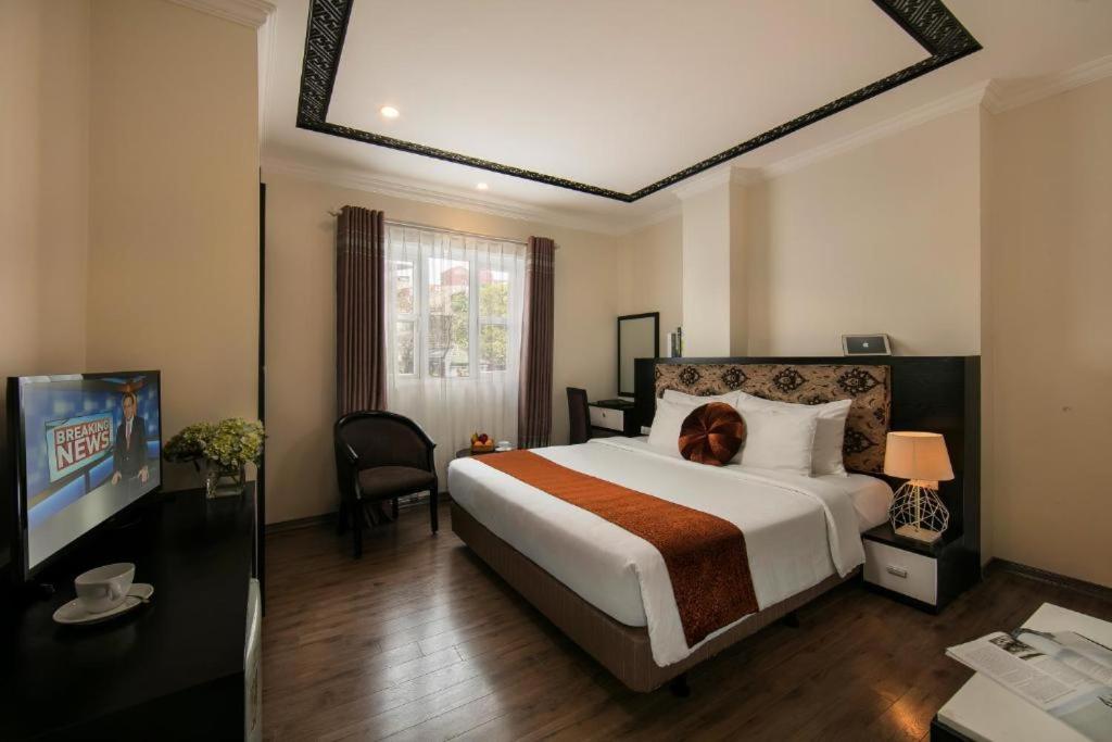 um quarto com uma cama com um cão sentado nela em Serenity Diamond Hotel 1E Cửa Đông - by Bay Luxury em Hanói