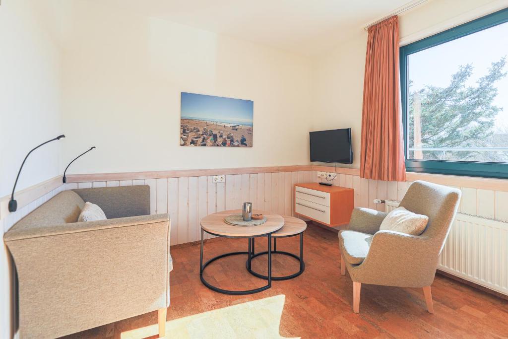 a living room with a couch and two chairs and a table at Appartement Greenlön in Westerland