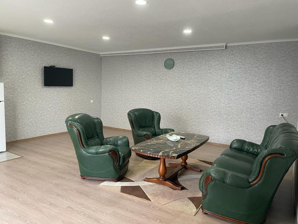 a living room with green chairs and a table at House in Mtskheta in Mtskheta
