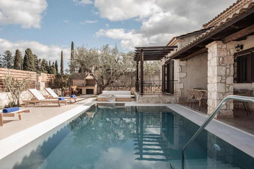 a swimming pool in a backyard with a house at Viatzo Villas in Laganas