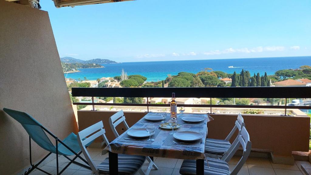 a table on a balcony with a view of the ocean at T2 à Saint-Clair - Vue exceptionnelle ! Classé 3 étoiles in Le Lavandou