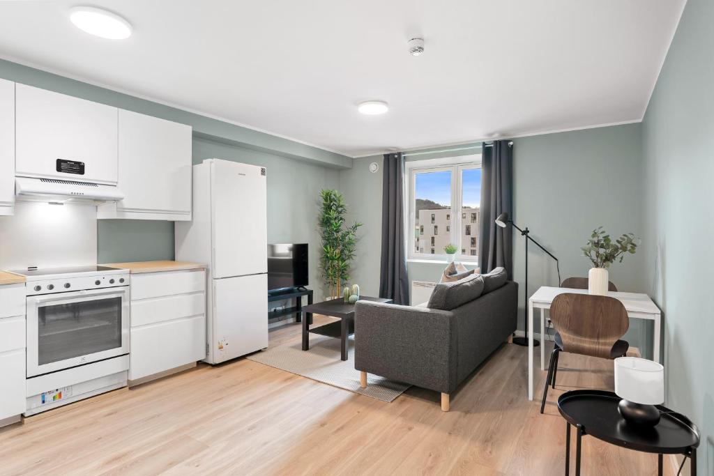 cocina y sala de estar con sofá y mesa en Forenom Serviced Apartments Bergen Skottegaten, en Bergen
