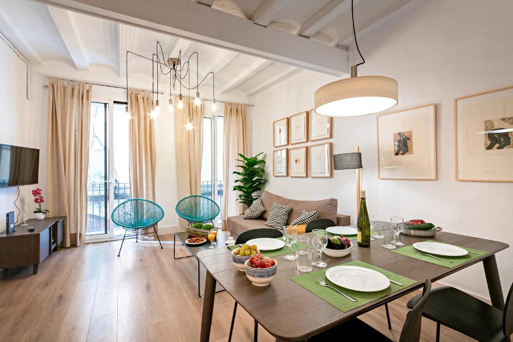 a living room with a table and a dining room at Habitat Apartments Born in Barcelona