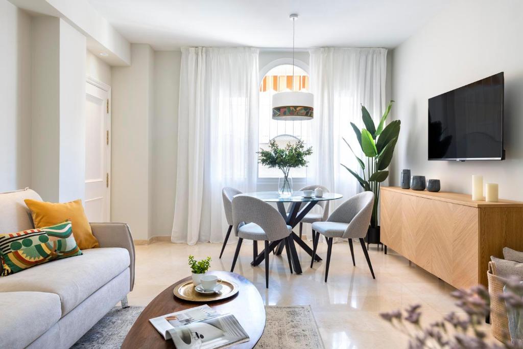 sala de estar con sofá y mesa en Magno Apartments Ruiseñor, en Sevilla