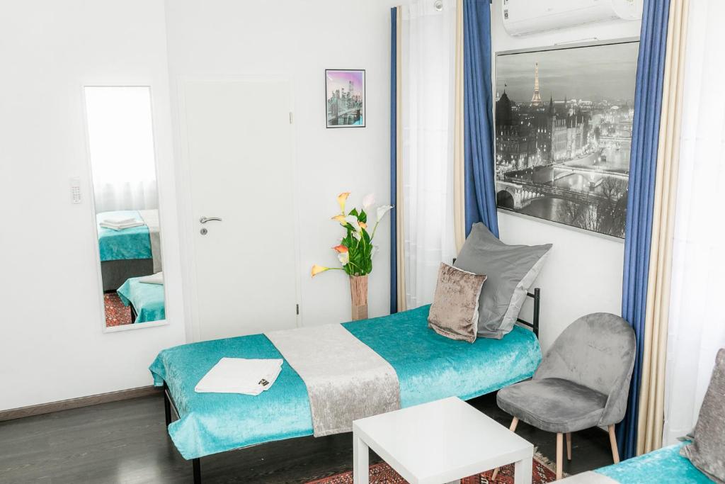 een kleine kamer met een bed en een stoel bij Tau Design Hotel in Erlangen