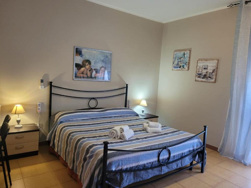 1 dormitorio con 1 cama con 2 toallas en Villa Eleila Affittacamere, en Terracina