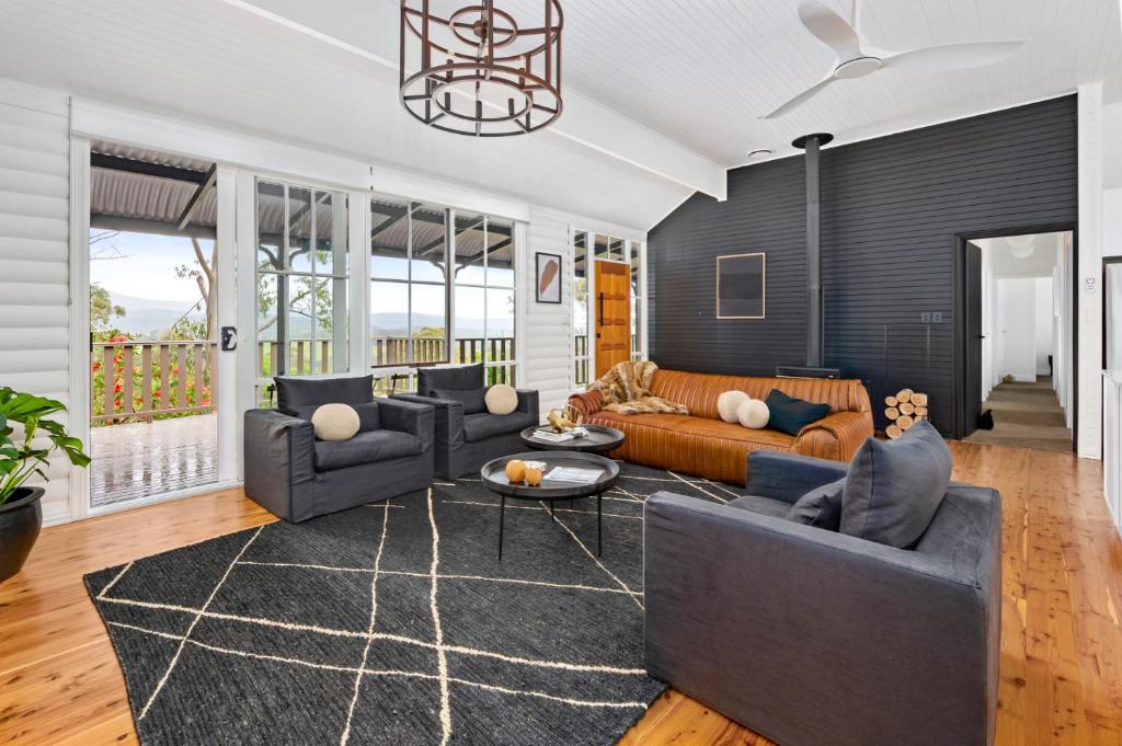 a living room with a couch and a table at Bellbird Lodge Barrington Tops in Bandon Grove