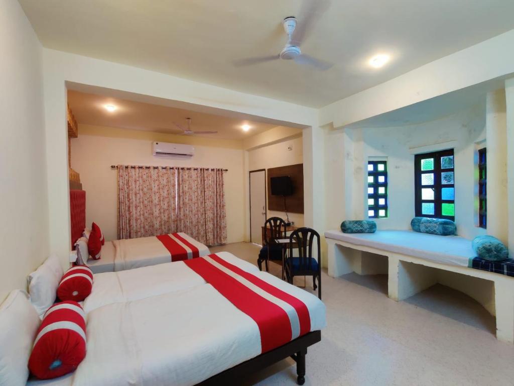 a bedroom with two beds and a desk in it at Hotel Tree of heaven in Udaipur
