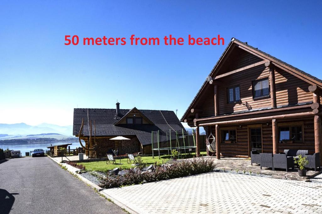 a house with the words meters from the beach at Bosorka Apartments Zrub Mara in Liptovský Trnovec