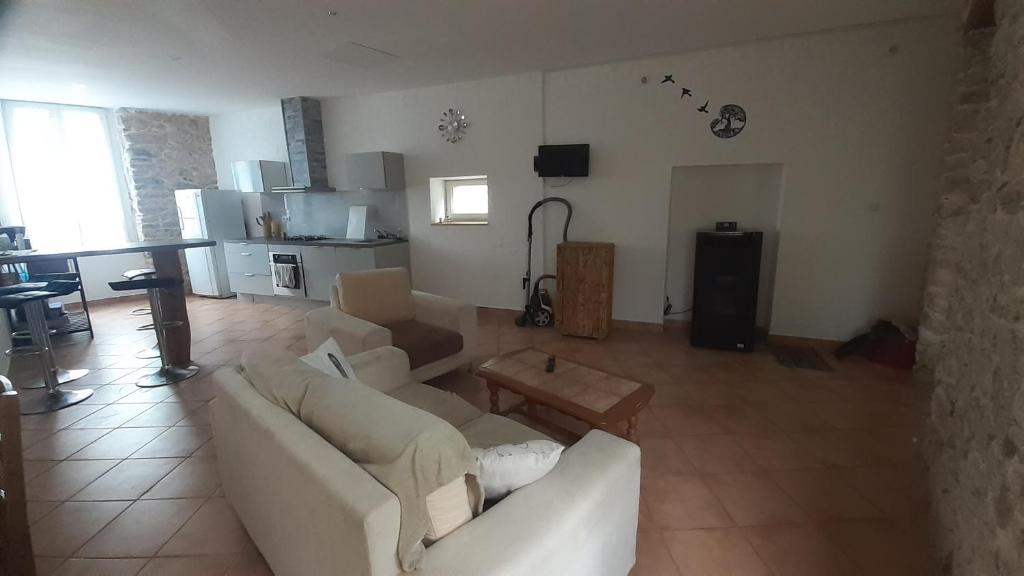 ein Wohnzimmer mit einem weißen Sofa und einem Tisch in der Unterkunft Appartemment situé a lacaune les bains in Lacaune