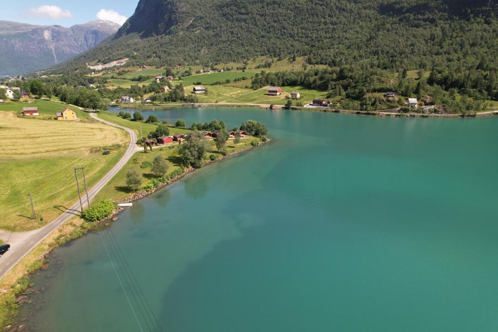 uma vista aérea de um rio com montanhas ao fundo em Løken Camping - trivelig og idyllisk ved vannet em Olden