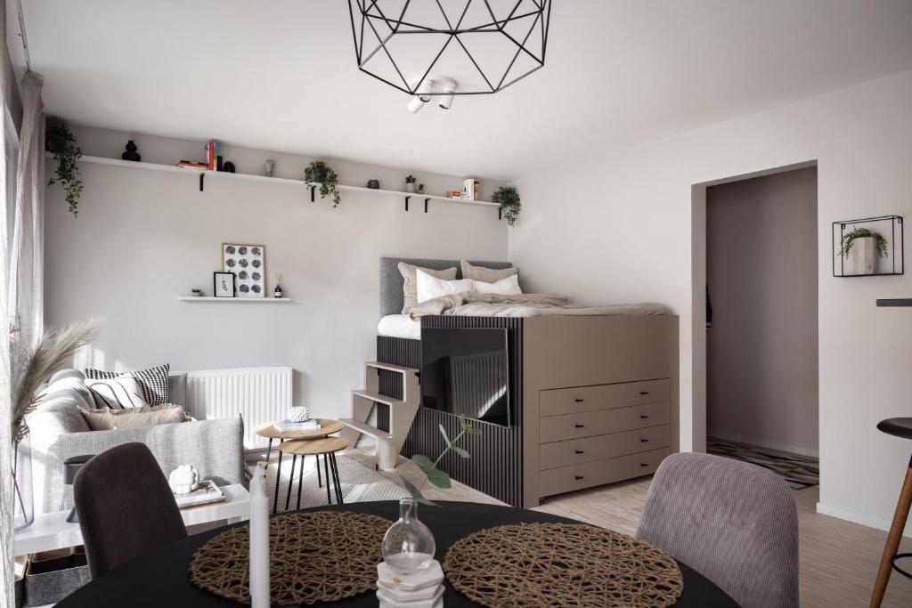 a living room with a bed and a table and chairs at Peaceful Scandinavian Studio - 19mins from City Centre in Stockholm