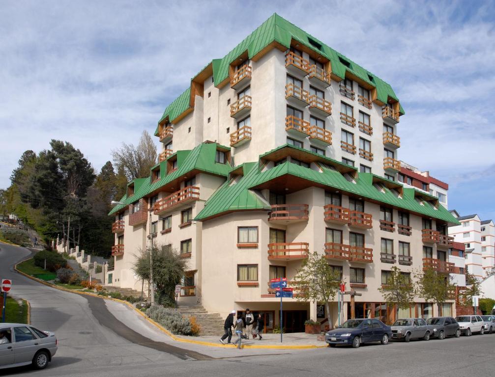 a large apartment building with a green roof at Soft Bariloche Hotel in San Carlos de Bariloche