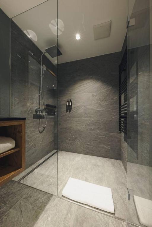 a bathroom with a shower with a glass door at Alpenhotel Montafon & SPA in Schruns