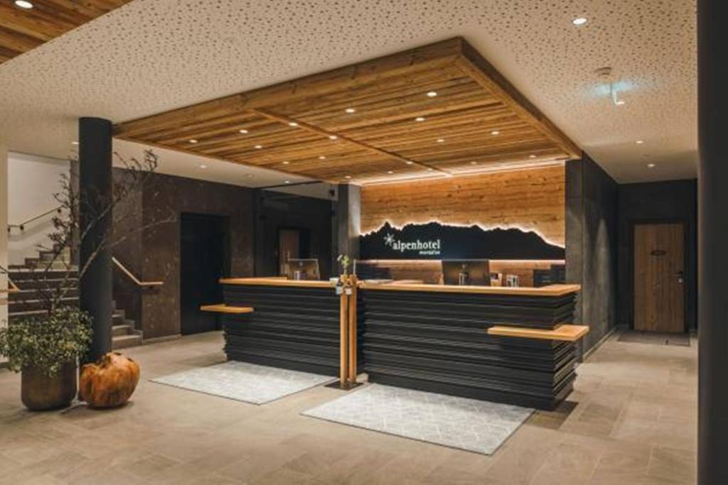 a restaurant with a counter in a building at Alpenhotel Montafon & SPA in Schruns