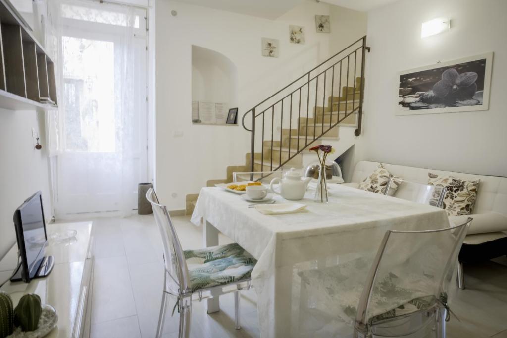 een witte eetkamer met een tafel en stoelen bij A Casa di Sonia in Siracusa