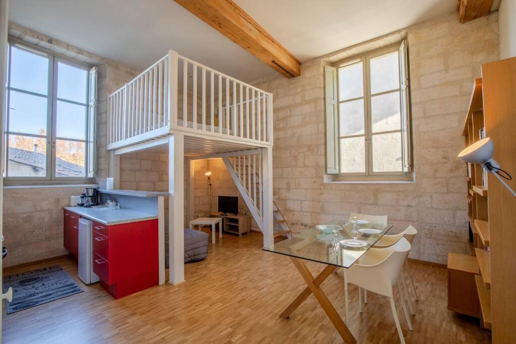 une pièce avec un escalier et une table et une cuisine dans l'établissement Yani - Grand studio intra-muros cadre exceptionnel, à Avignon