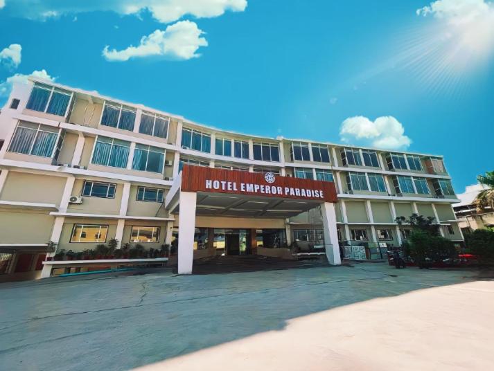 un edificio de hotel con un cartel delante en Hotel Emperor Paradise, en Bilāspur