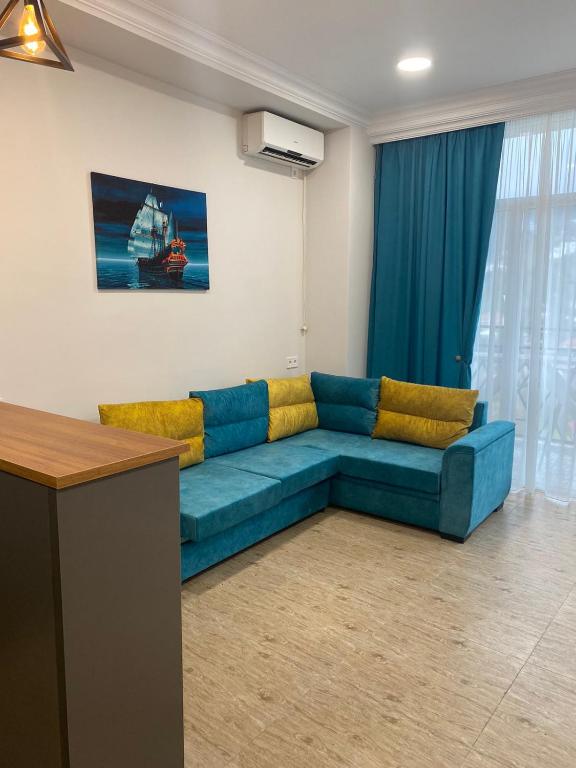 a living room with a blue couch in a room at All seasons in Gonio beach in Gonio