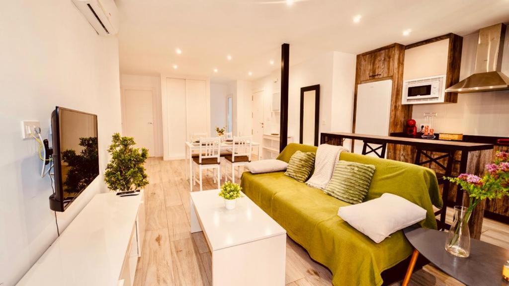 a living room with a yellow couch and a kitchen at PRECIOSO PISO EN PLENO CENTRO Con PARKING OPCIONAL in Granada