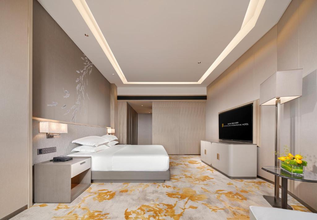een hotelkamer met een bed en een flatscreen-tv bij Jinyun Jingjiang International Hotel in Jinyun