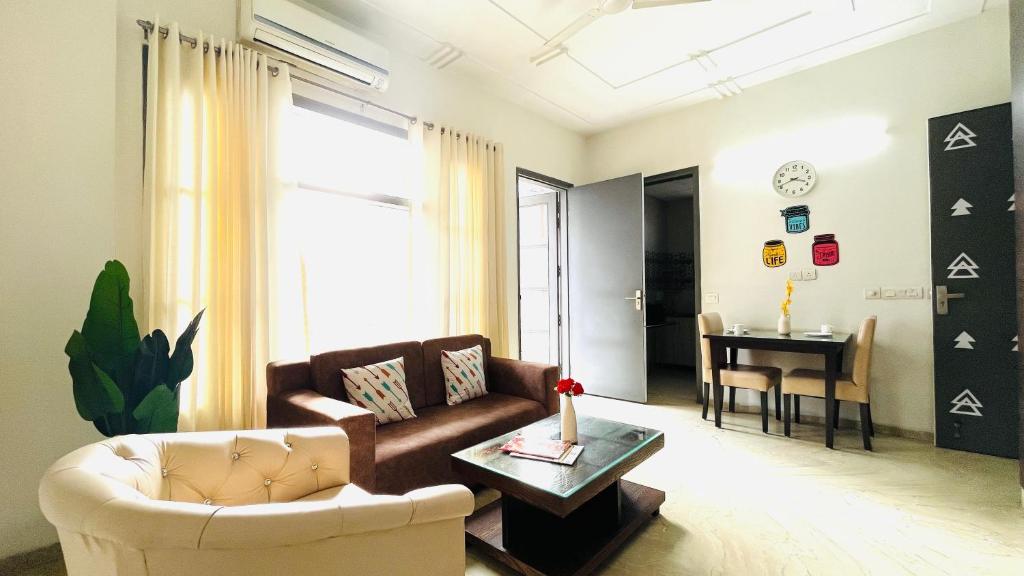 - un salon avec un canapé et une table dans l'établissement BluO 1BHK Medanta Medicity, Kitchen, Balcony, Lift, à Gurgaon