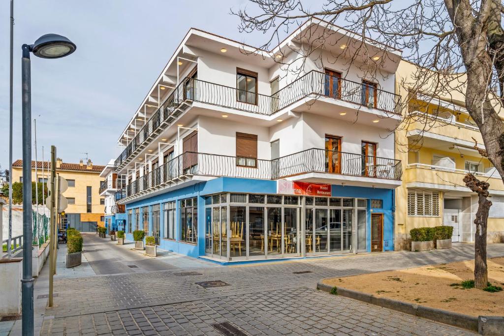 - un bâtiment blanc et bleu dans une rue de la ville dans l'établissement Hostal La Marina, à Platja d'Aro