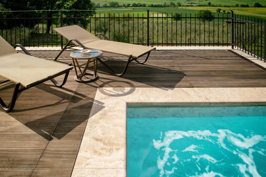 una silla y una silla junto a la piscina en Tenuta dei Mori-Wine Relais Events, en Villanova