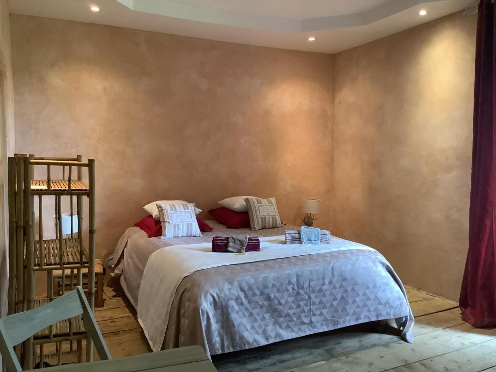 a bedroom with a bed and a chair at Domaine de Montagnol in Sauveterre