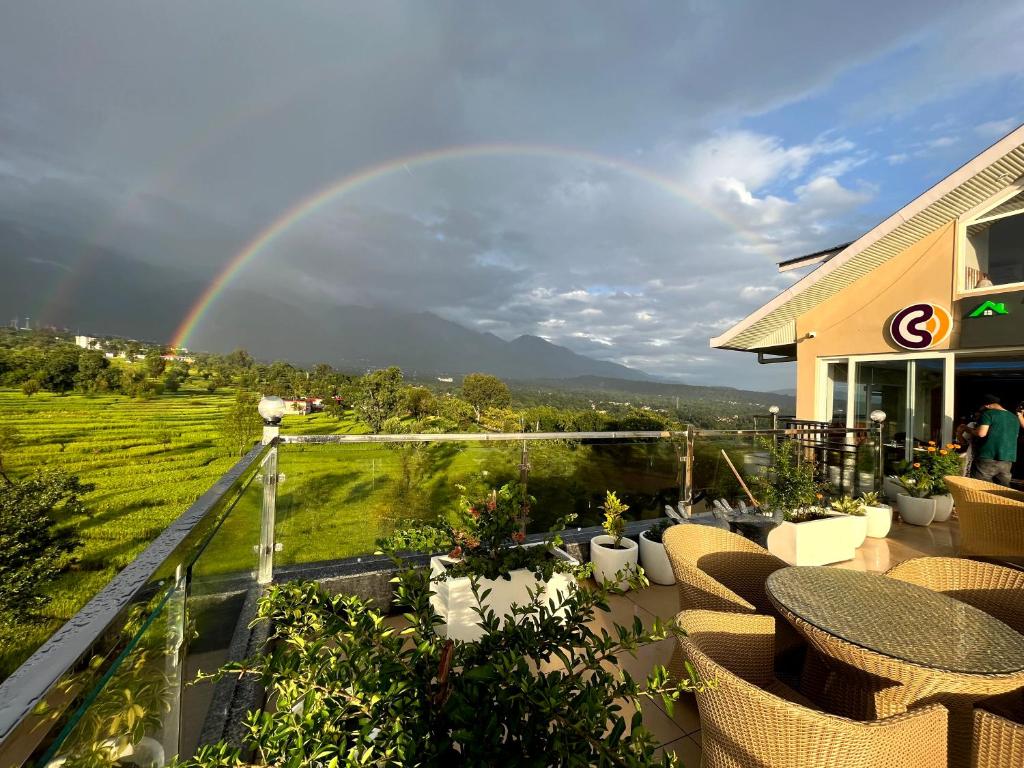 un arcobaleno su un patio con tavoli e sedie di Click Collection The Abode, Dharamshala a Dharamshala
