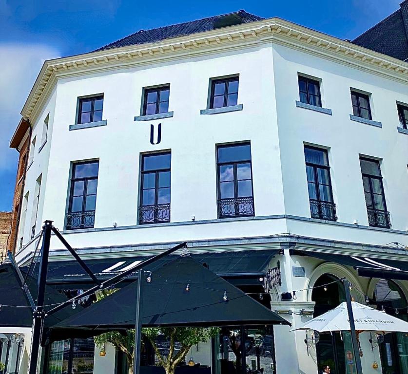 - un bâtiment blanc avec un parasol devant dans l'établissement U Eat & Sleep Antwerp, à Anvers