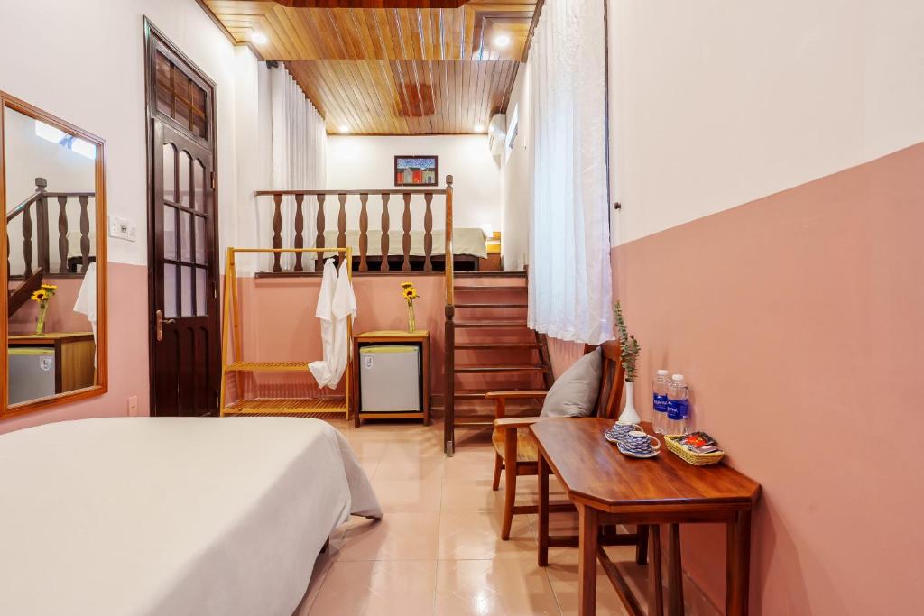 - une chambre avec un lit, une table et un escalier dans l'établissement An Hiên Homestay Hội An, à Hội An