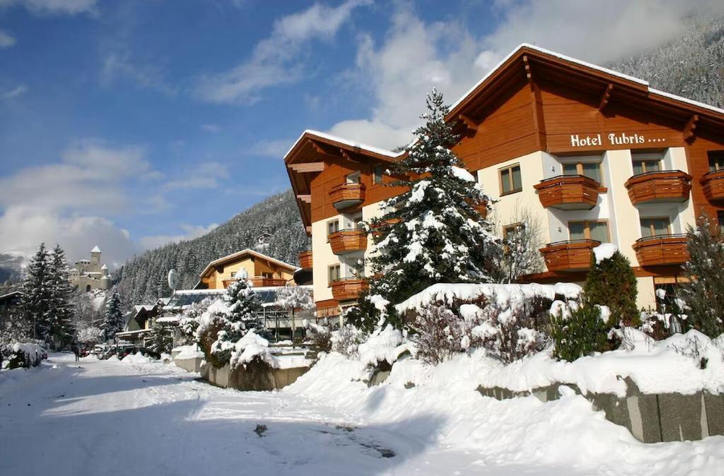 a hotel in the snow with a building at Hotel Tubris Garnì Campo Tures in Campo Tures