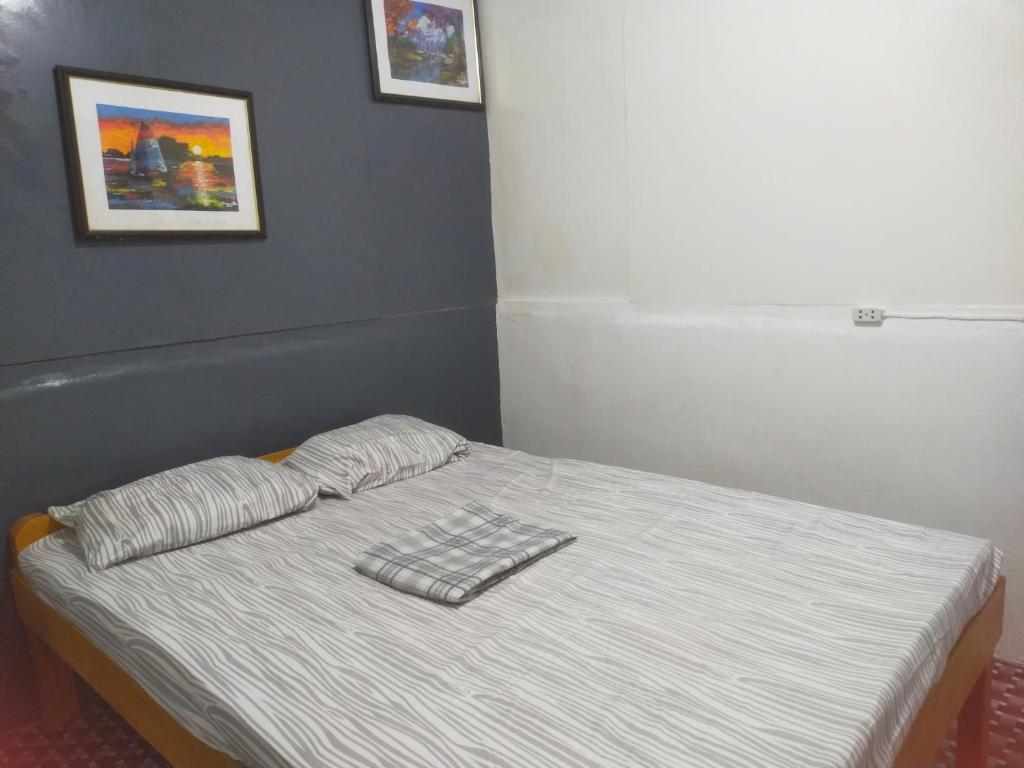 uma cama com duas almofadas num quarto em Nomad Homestay em Moalboal