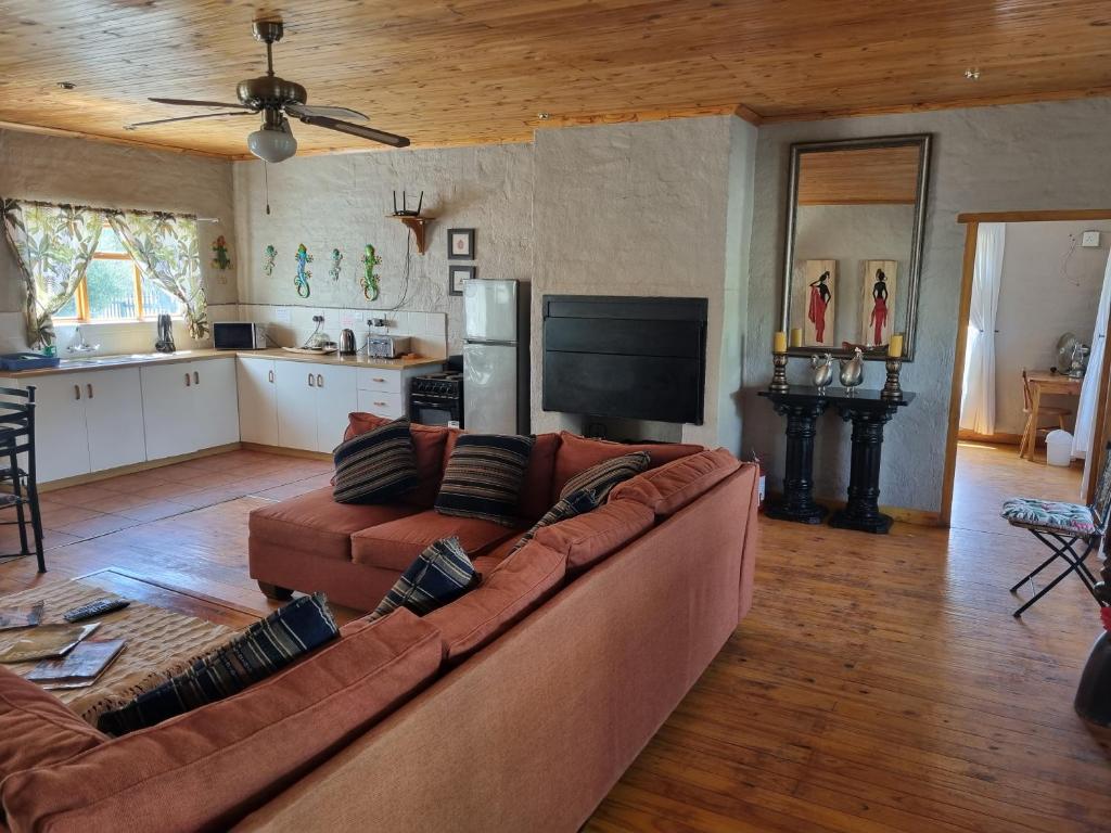 a living room with a brown couch and a kitchen at Baroe House in Sutherland