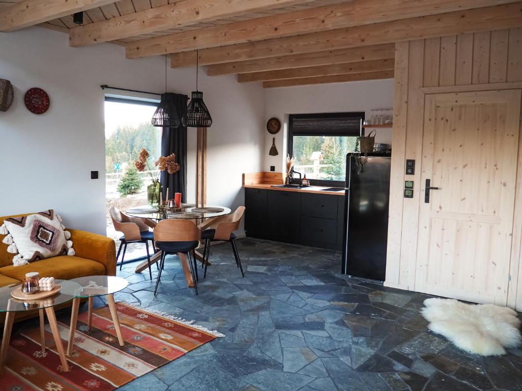 cocina y sala de estar con sofá y mesa en Owczarnia Tatry en Bukowina Tatrzańska