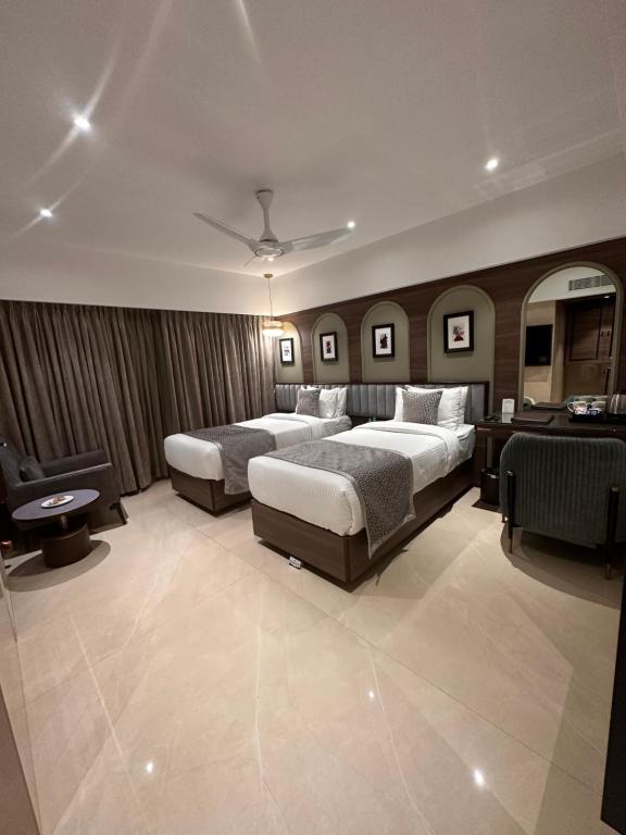 a hotel room with two beds and a desk at The International by Tunga in Mumbai