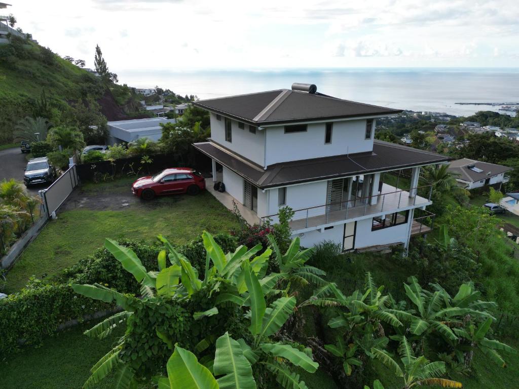 une maison sur une colline avec l'océan en arrière-plan dans l'établissement Manapiti on the hill, à Papeete