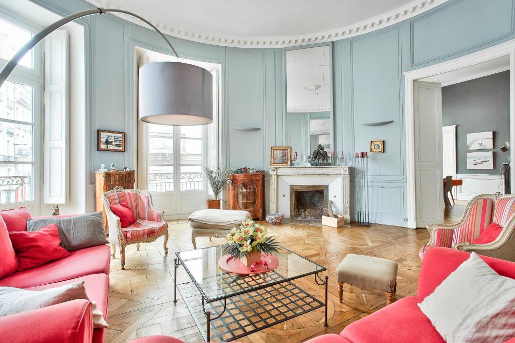 un salon avec des meubles rouges et une cheminée dans l'établissement En plein centre ville appartement d'exception, à Nantes