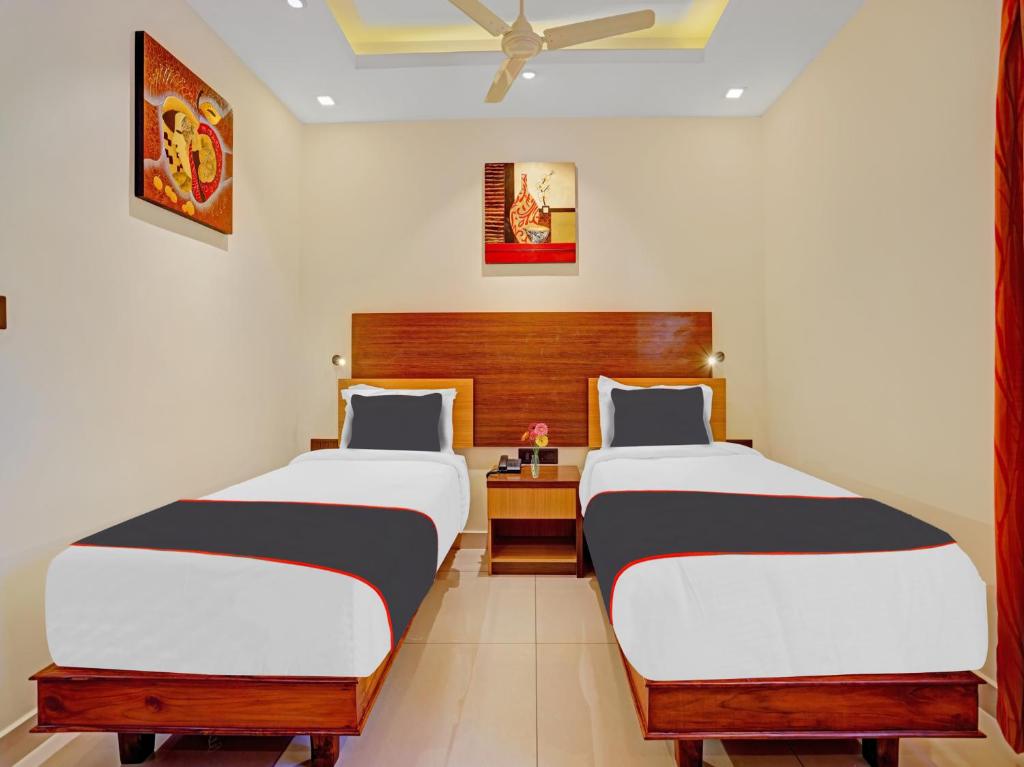um quarto com 2 camas e uma cabeceira em madeira em Pallava Rajadhani em Trivandrum