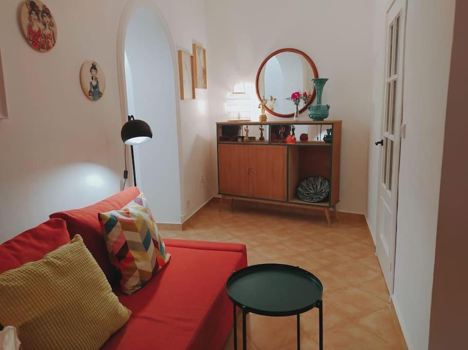 sala de estar con sofá rojo y espejo en Casa con piscina cerca de Sevilla, en Carrión de los Céspedes