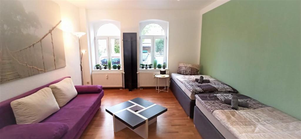 salon z fioletową kanapą i stołem w obiekcie Apartment für bis zu 7 Personen mit Balkon w mieście Halberstadt