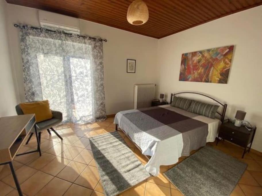 1 dormitorio con cama, escritorio y ventana en Laki's House Οροφοδιαμέρισμα με σοφίτα en Thermo