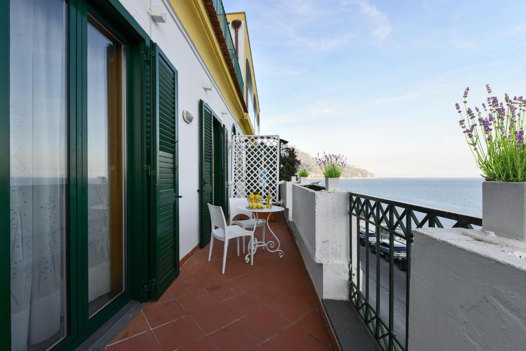 een balkon met een tafel en stoelen en uitzicht op de oceaan bij La casa del Conte - Amalfi Coast in Amalfi