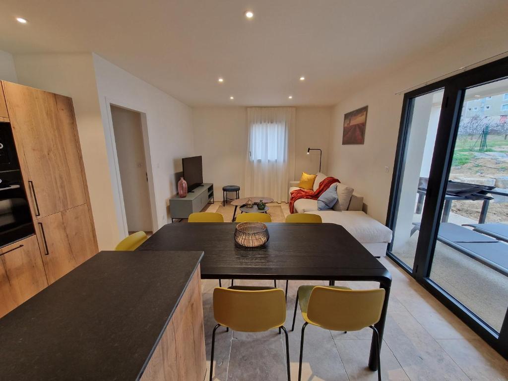 un salon avec une table et des chaises dans une pièce dans l'établissement Les Papillons du Ventoux - L'Aurore de Provence - twee slaapkamerappartement met terras en tuin, à Malaucène