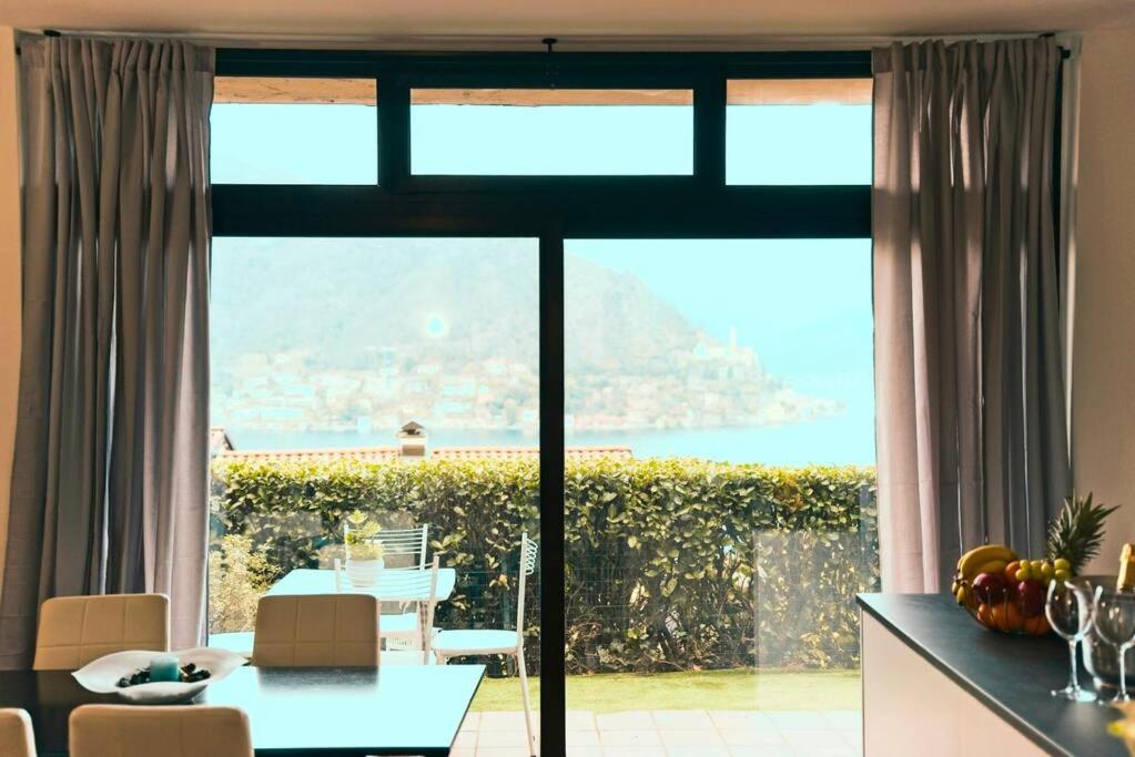 een keuken en eetkamer met een groot raam bij Miralago Lugano sporting club in Cuasso Al Monte